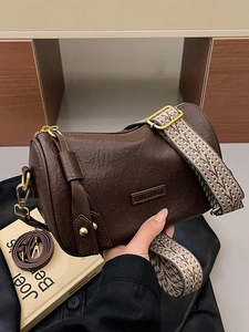 Retro dark brown cylinder crossbody bag with vintage leather texture and wide strap