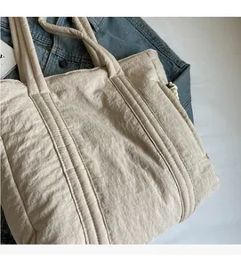 Detail of soft beige tote bag with crinkled texture fabric and dual top handles