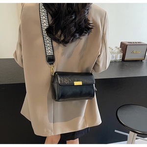Detail of vintage black leather crossbody bag with geometric wave pattern wide strap