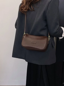 Retro brown pillow crossbody bag with wide shoulder strap and gold hardware details