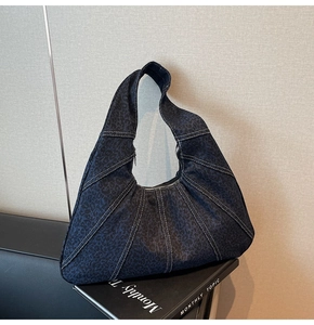 Detail of dark blue leopard print hobo bag featuring white contrast stitching and texture