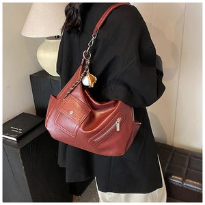 Vue détaillée du sac cabas vintage bordeaux avec anneaux et pendentif de baseball