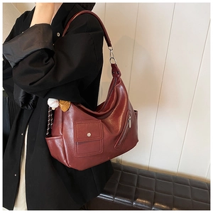 Détail du sac hobo bordeaux avec breloque baseball et poches multifonctionnelles