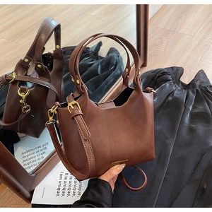 Vue détaillée d'un sac seau en cuir PU marron avec garnitures dorées sur miroir