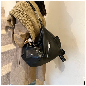 Détail d'un grand sac hobo noir vintage avec zips et pendentif de baseball décoratif