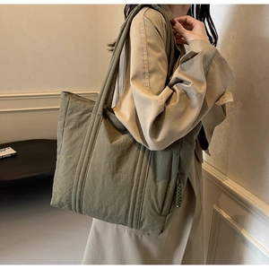 Detail of army green nylon tote bag with vertical stitching and textured fabric finish