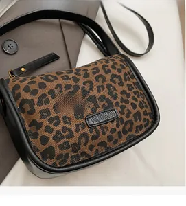 Détail de gros plan du sac léopard avec l'étiquette de marque en cuir de MUONJIN