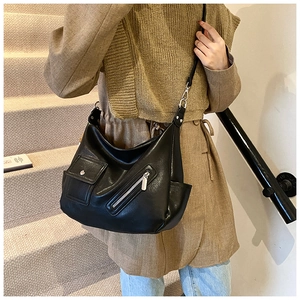 Détail du sac hobo noir avec ferrures métalliques et poche de style cargo