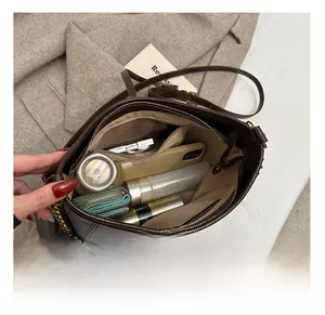 Vista interna della borsa tote in pelle marrone scuro con smartphone e cosmetici