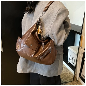 Détail du sac seau en cuir PU marron foncé avec fermeture éclair et bandoulière tressée