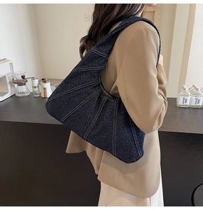 Detail of dark blue leopard print underarm bag with white contrast stitching and canvas texture