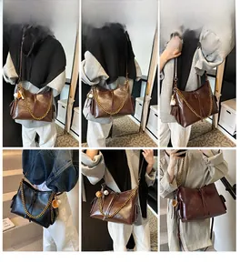 Dettagli della borsa tote in pelle con catena dorata e ciondolo morbido di peluche