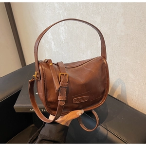 Détails du sac oreiller marron vintage avec coutures irrégulières et texture cuir raffinée