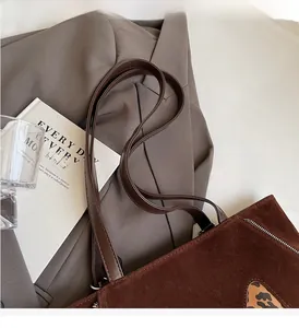 Detailed close-up of dark brown suede tote bag with leopard print accent and dual handles
