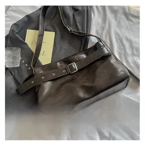 Detail view of large dark brown soft leather tote bag with stylish silver buckle accent