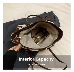 Internal capacity view of cow print plush tote bag showing spacious interior and zip pocket
