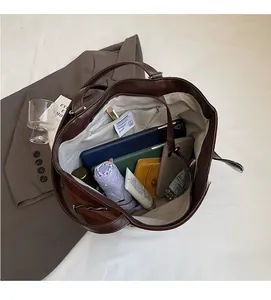 Top view of a spacious brown leather tote bag showing organized interior storage and items