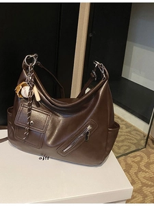 Sac à main vintage en cuir marron foncé avec poches multiples et breloque de sport