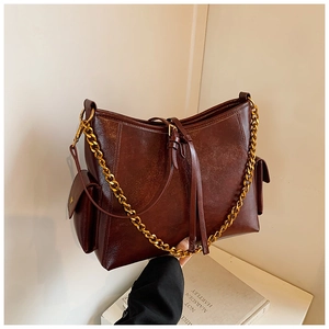 Dettaglio della borsa a tracolla vintage marrone scuro con catena dorata e tasche