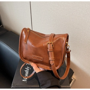 Gros plan détaillé d'un sac bandoulière vintage en cuir marron avec fini texturé