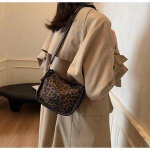 Détail du sac bandoulière imprimé léopard avec bandoulière en cuir noir et dorures