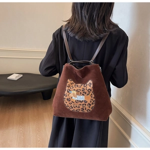 Detail of suede backpack with leopard cat ear patch and embroidered dachshund on back