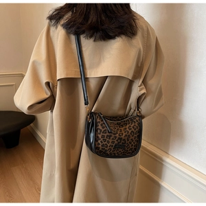 Détail du sac à bandoulière léopard avec garniture en cuir noir et fermeture éclair dorée