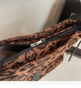 Detailed close-up of the smooth silver metal zipper on a large leopard print tote bag