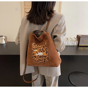 Rear view of brown suede backpack with leopard cat patch and cartoon dog embroidery