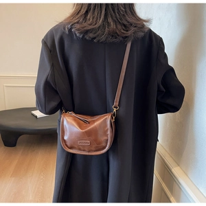 Détail d'un sac à bandoulière marron en cuir PU vintage avec couture et sangle réglable