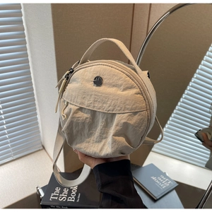 Détail du sac à main rond en nylon avec logo métal M FASHION et bandoulière tissée