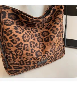 Close-up of leopard print tote bag featuring fuzzy texture and a black zipper closure