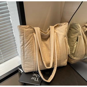 Detail view of large tote bag with side zipper pocket and soft nylon texture