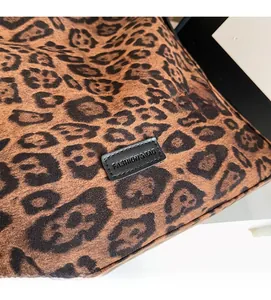 Detailed close-up of leopard print fabric texture and embossed fashion leather label