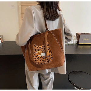 Detail of suede tote bag featuring leopard cat patch and dachshund embroidery detail
