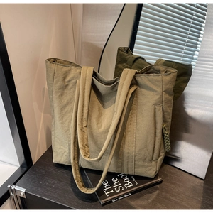 Olive green high-capacity nylon tote bag with wide strap and side woven details