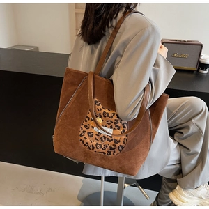 Detailed close-up of brown suede tote bag with leopard print patch and dog embroidery