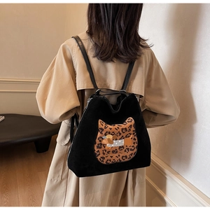 Detail of black backpack with leopard cat patch and cartoon dog embroidery