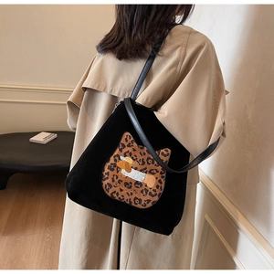 Close-up of black suede tote bag with leopard cat patch and dog embroidery detail