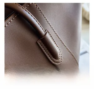Close-up of fine stitching and pebble leather texture on deep brown tote bag detail