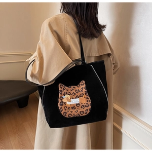 Detail of black suede tote bag with leopard cat patch and dog embroidery design