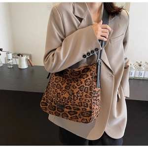 Detail of leopard print shoulder bag with black leather strap and silver metal buckle