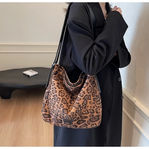 Close-up of a large leopard print tote bag with black adjustable leather shoulder strap