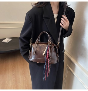 Dettaglio borsa Boston marrone scuro con corda intrecciata sul manico e tracolla