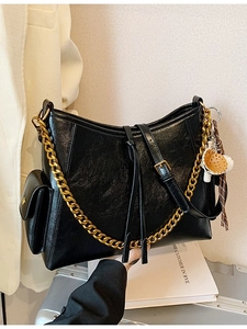 Borsa tote in pelle nera lucida con grossa catena dorata e dettagli di frange