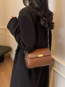Vintage brown leather crossbody pillow bag with gold clasp shown on a model
