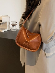 Sac à épaule vintage en cuir marron avec logo embossé et fermeture éclair épurée