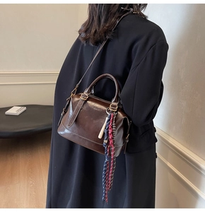 Dettaglio borsa Boston in pelle marrone vintage con nappa intrecciata e logo impresso