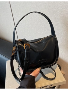 Sac polochon vintage en cuir noir avec détails dorés et bandoulière réglable
