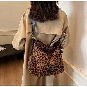 Detail of leopard print shoulder bag featuring adjustable black strap and fashion logo label